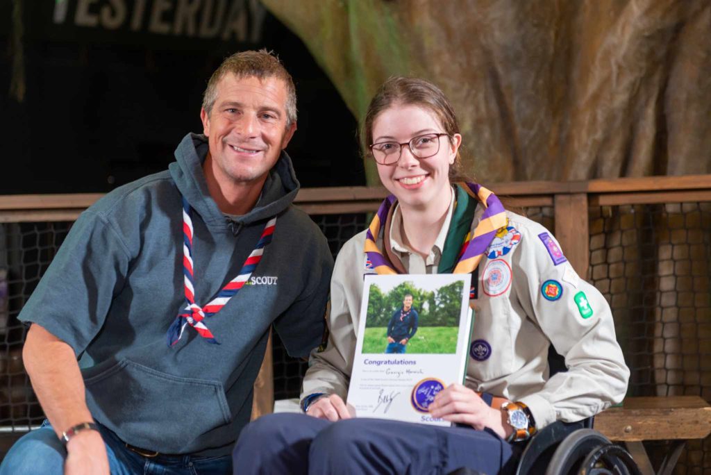 Bear Grylls (l) presenting a Never Give Up award certificate to Georgie (r).