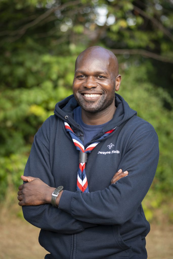 Dwayne Fields, the new Chief Scout, stands against a forest backdrop.