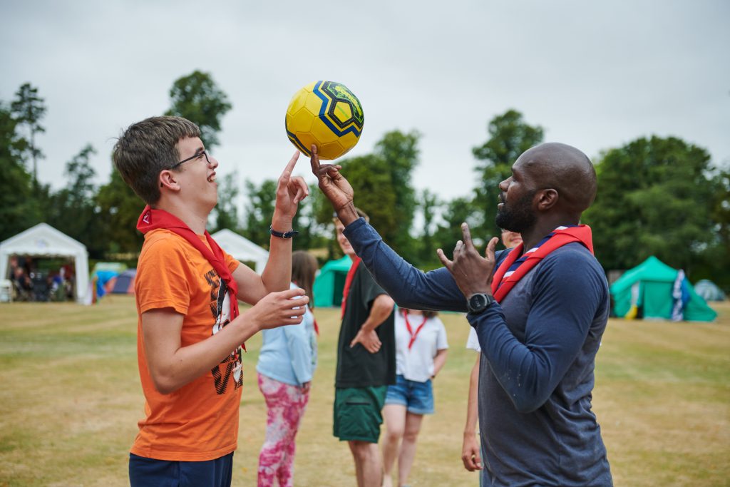 A scout plays with a ball with Dwayne Fields, new Chief Scout.